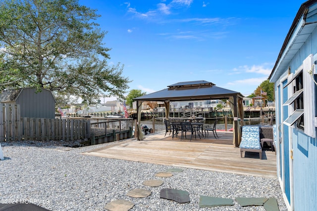 wooden deck with a gazebo, outdoor dining space, and fence