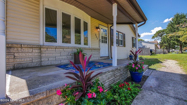 view of side of home featuring a yard and covered porch