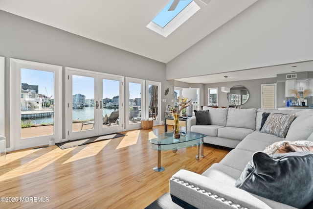 149 Valencia Dr, Brick, NJ 08723 - living area featuring a water view, plenty of natural light, high vaulted ceiling, a skylight, and wood finished floors