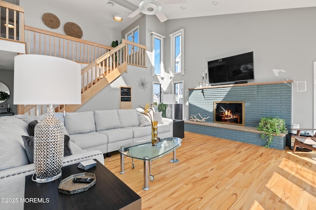 149 Valencia Dr, Brick, NJ 08723 - living room with wood finished floors, a ceiling fan, stairway, a fireplace, and high vaulted ceiling