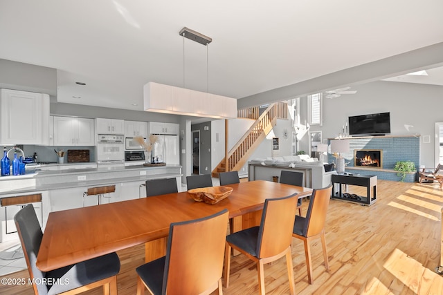 149 Valencia Dr, Brick, NJ 08723 - dining space with a ceiling fan, a fireplace, light wood-type flooring, and stairway