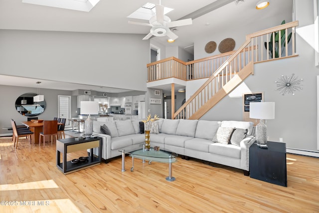 149 Valencia Dr, Brick, NJ 08723 - living room with high vaulted ceiling, a skylight, ceiling fan, stairway, and wood finished floors