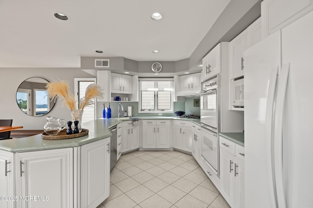 149 Valencia Dr, Brick, NJ 08723 - kitchen with appliances with stainless steel finishes, a peninsula, light tile patterned flooring, white cabinets, and recessed lighting