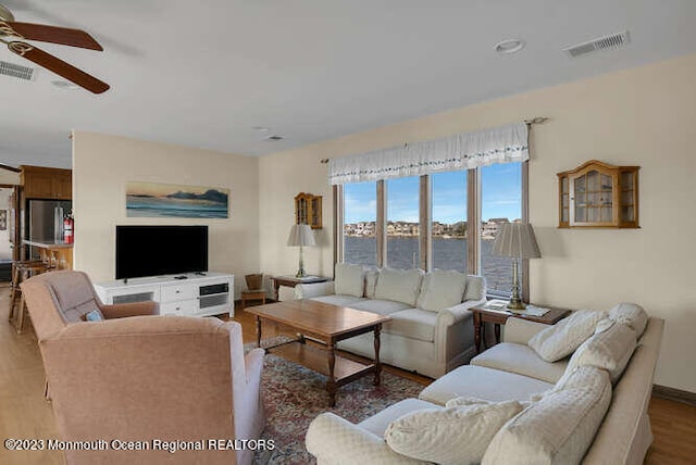 living room featuring ceiling fan and dark hardwood / wood-style floors