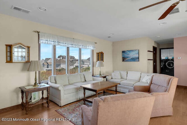 living room with ceiling fan, washer / clothes dryer, and hardwood / wood-style floors