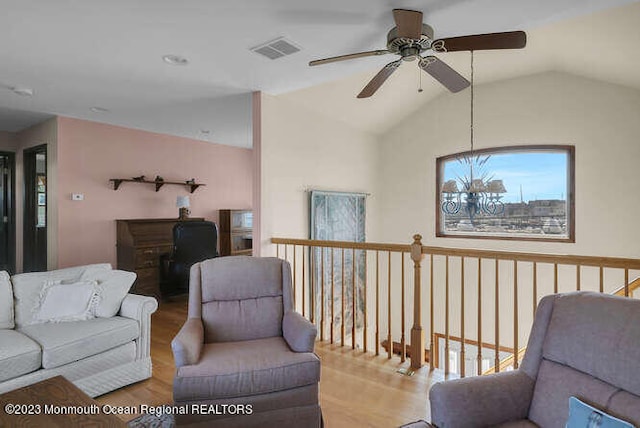 living room with ceiling fan, vaulted ceiling, and hardwood / wood-style floors