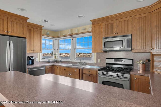 kitchen with appliances with stainless steel finishes, sink, and backsplash