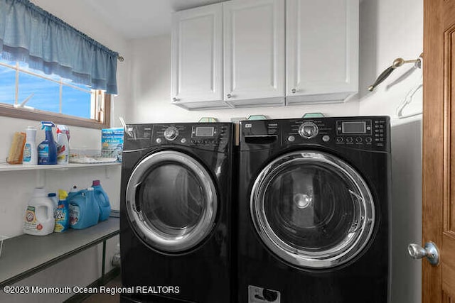 washroom with cabinets and washing machine and clothes dryer