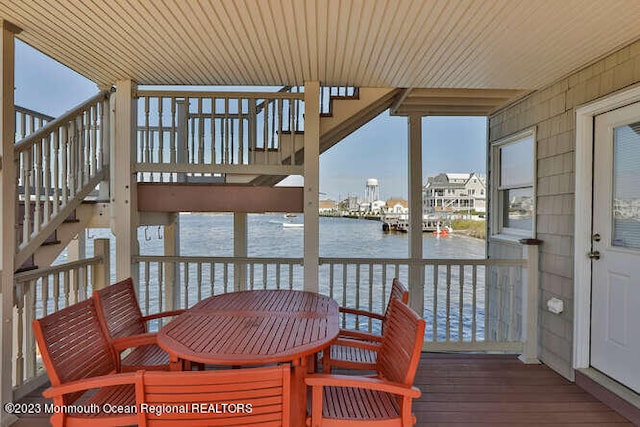 sunroom with wooden ceiling and a water view