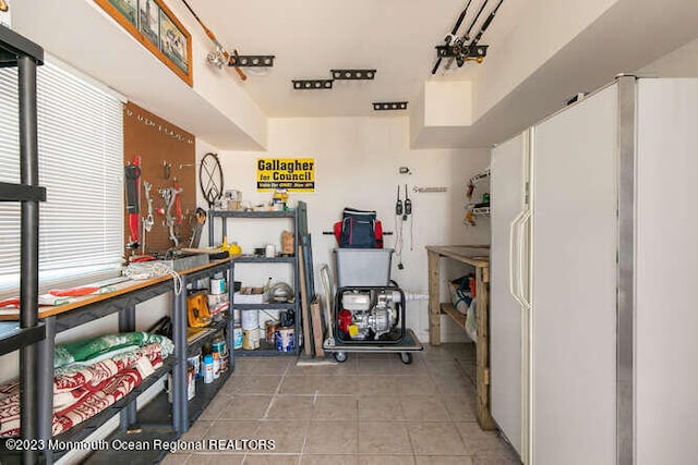 miscellaneous room featuring a workshop area and light tile patterned floors