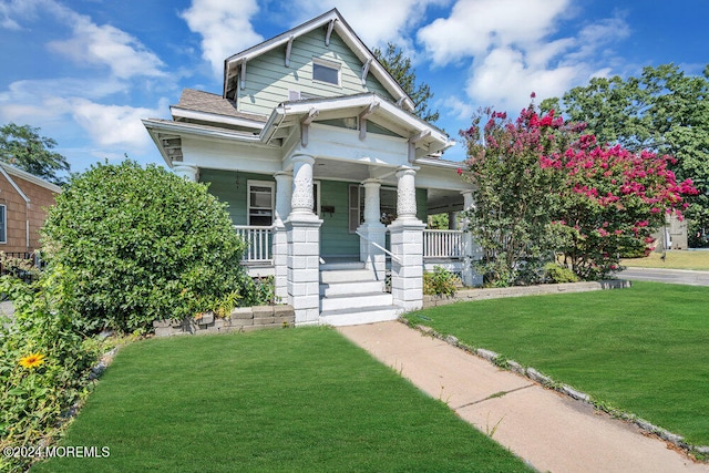 craftsman house with a porch and a front lawn