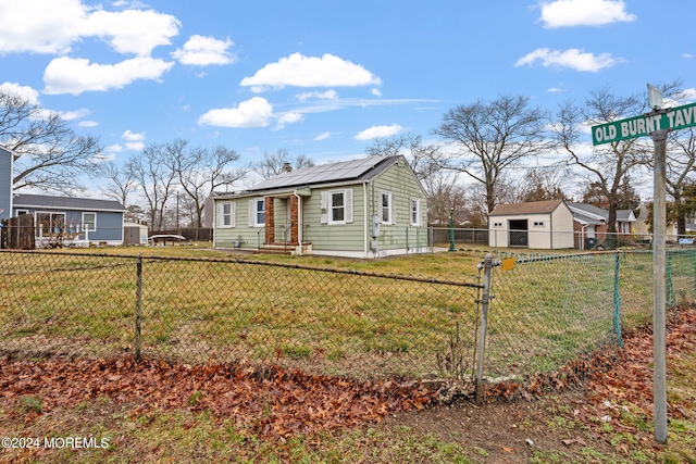 view of front of house featuring a front yard and an outbuilding