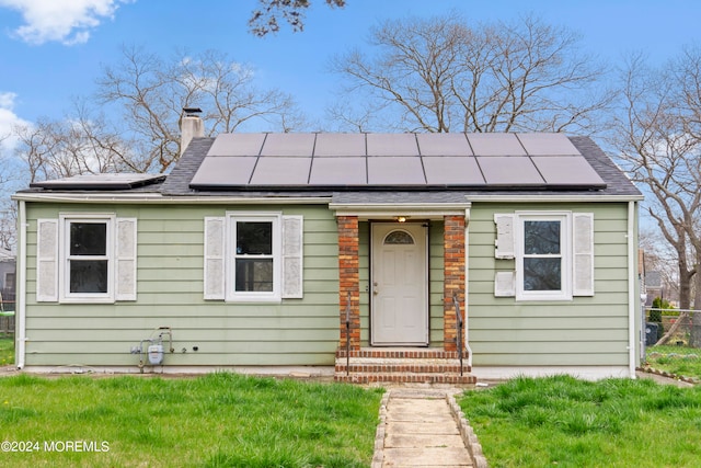 view of front of home with solar panels and a front yard