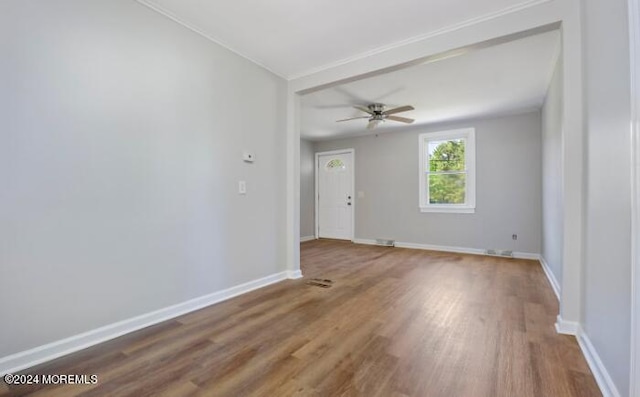 empty room with ceiling fan, baseboards, and wood finished floors