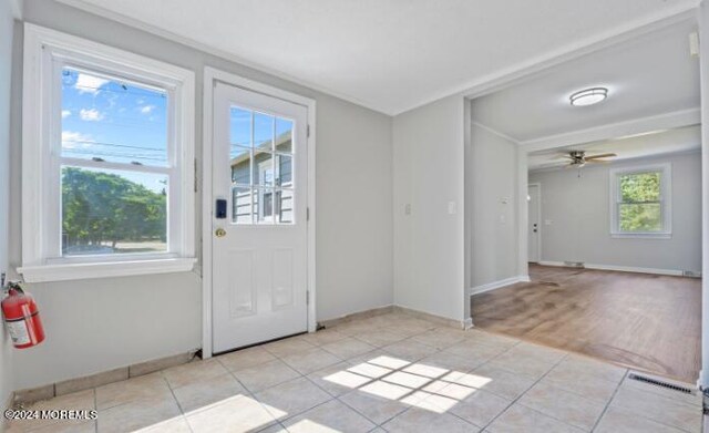 doorway to outside featuring ceiling fan and light tile patterned flooring