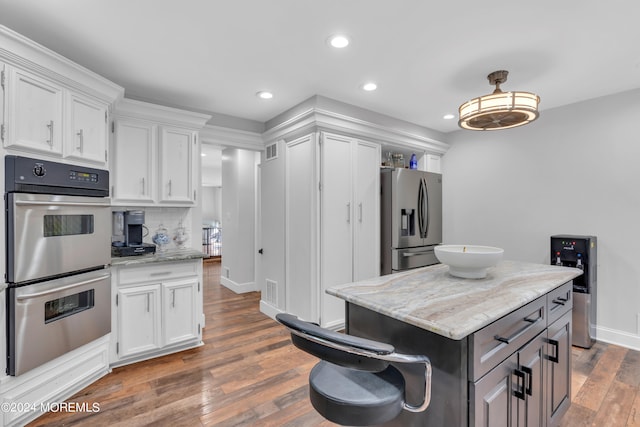 kitchen with a kitchen island, stainless steel appliances, dark hardwood / wood-style flooring, and tasteful backsplash