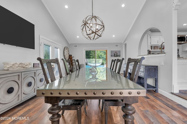 dining space with dark wood-type flooring, vaulted ceiling, a wealth of natural light, and an inviting chandelier