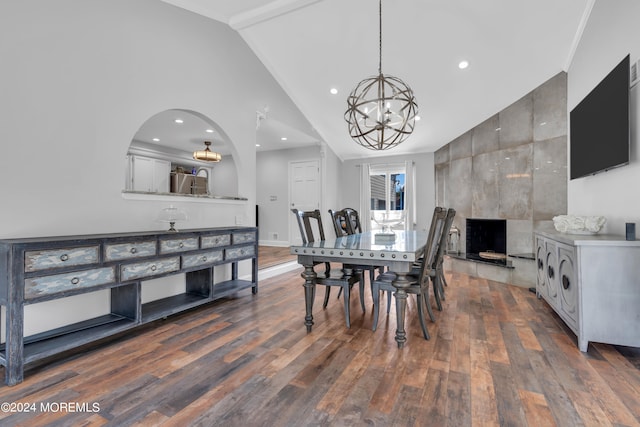 dining area with dark hardwood / wood-style floors, high vaulted ceiling, and a notable chandelier