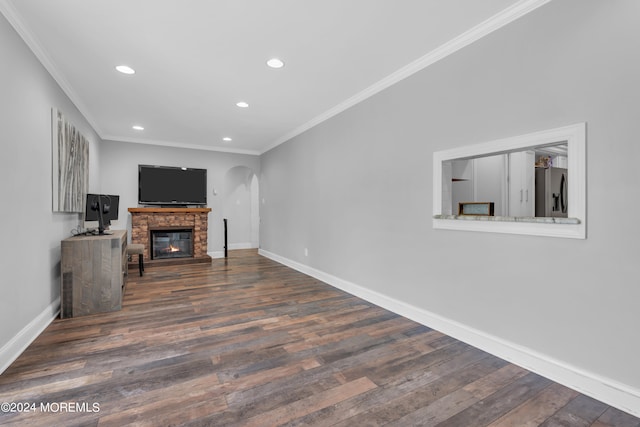 living room with crown molding, dark wood-type flooring, and a fireplace