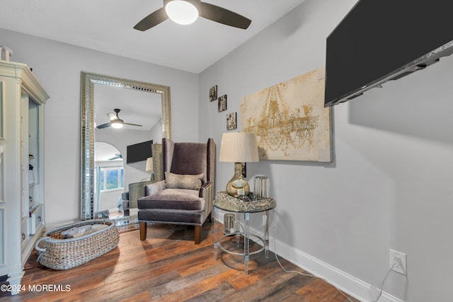 sitting room with dark wood-type flooring and ceiling fan