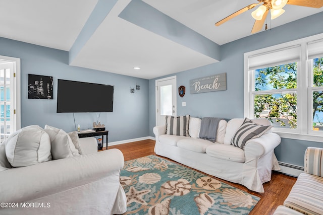 living room featuring ceiling fan, baseboard heating, and dark hardwood / wood-style flooring