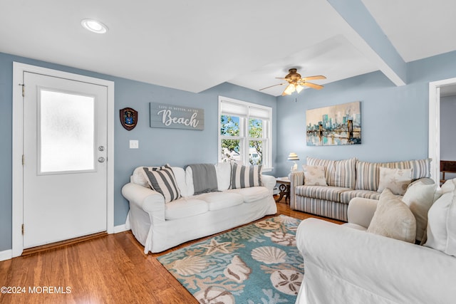 living room with ceiling fan, beamed ceiling, and hardwood / wood-style floors