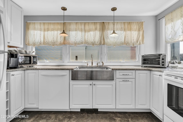 kitchen featuring pendant lighting, sink, white appliances, stone countertops, and white cabinetry