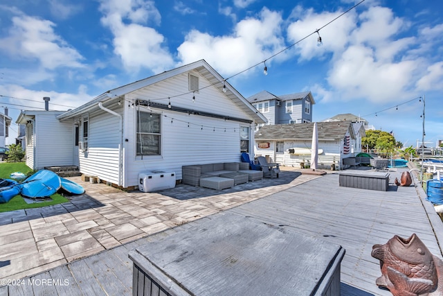 back of house featuring a deck and outdoor lounge area