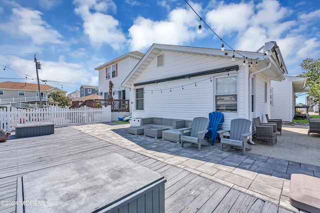 wooden deck with an outdoor living space and a patio