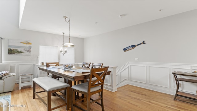 dining space with a notable chandelier and light hardwood / wood-style flooring