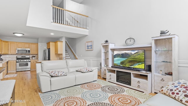 living room with light hardwood / wood-style flooring and a high ceiling