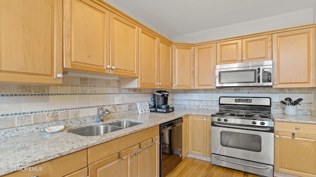 kitchen with light hardwood / wood-style flooring, stainless steel appliances, sink, and tasteful backsplash