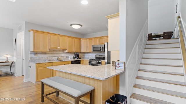 kitchen featuring appliances with stainless steel finishes, light hardwood / wood-style floors, tasteful backsplash, kitchen peninsula, and sink