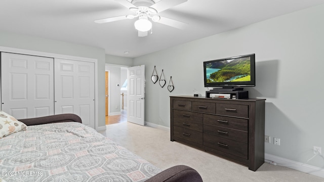 carpeted bedroom with ceiling fan and a closet