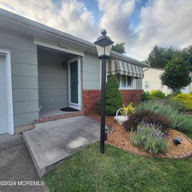 doorway to property featuring a porch and a yard