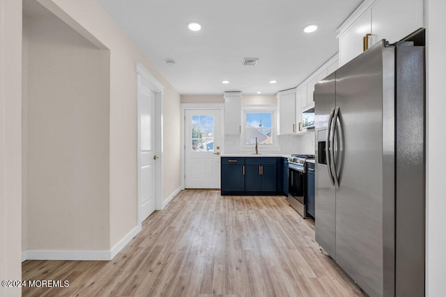 kitchen featuring blue cabinetry, appliances with stainless steel finishes, light hardwood / wood-style floors, sink, and white cabinets