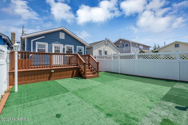 back of house featuring a yard and a deck