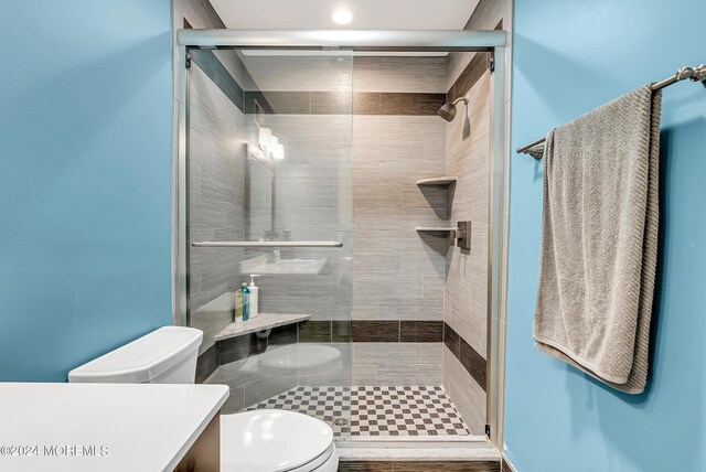 bathroom featuring vanity, toilet, and an enclosed shower