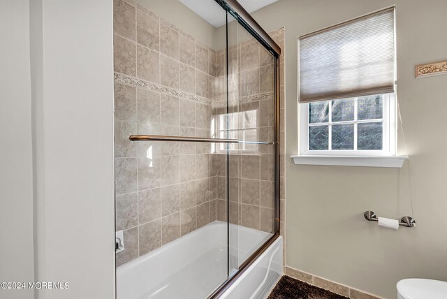 bathroom with toilet and enclosed tub / shower combo