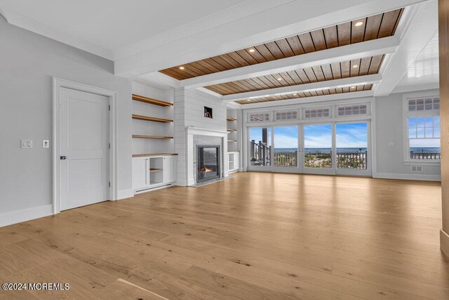 unfurnished living room with light wood-type flooring, beam ceiling, and wooden ceiling