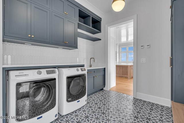 washroom with separate washer and dryer, cabinets, and sink