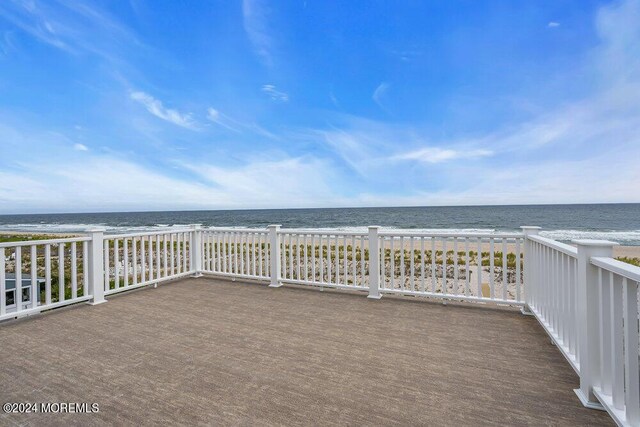 deck with a beach view and a water view