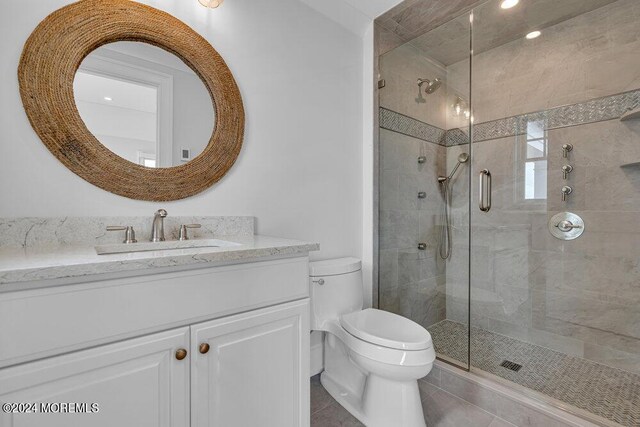 bathroom with tile patterned flooring, vanity, toilet, and a shower with door