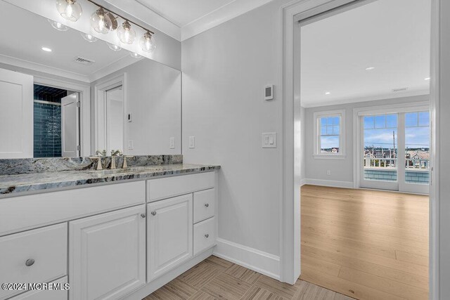 bathroom featuring hardwood / wood-style flooring, vanity, and crown molding