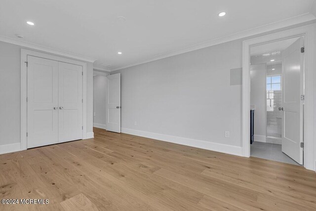 unfurnished bedroom with connected bathroom, crown molding, and light hardwood / wood-style floors