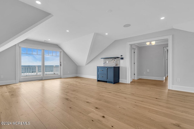 additional living space with vaulted ceiling and light hardwood / wood-style floors