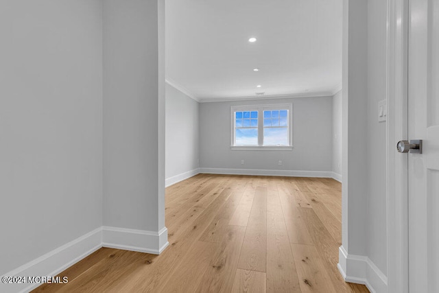 empty room with light wood-type flooring and ornamental molding