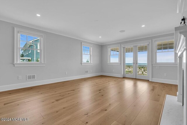 interior space with french doors, light wood-type flooring, and ornamental molding