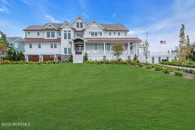 shingle-style home with metal roof, covered porch, a front lawn, and a standing seam roof