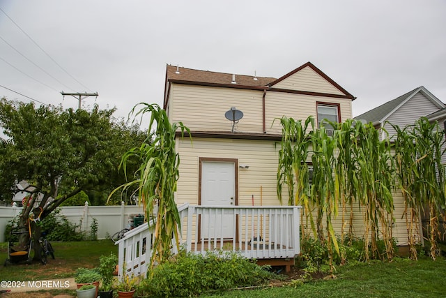 view of front of house featuring fence, a front lawn, and a wooden deck